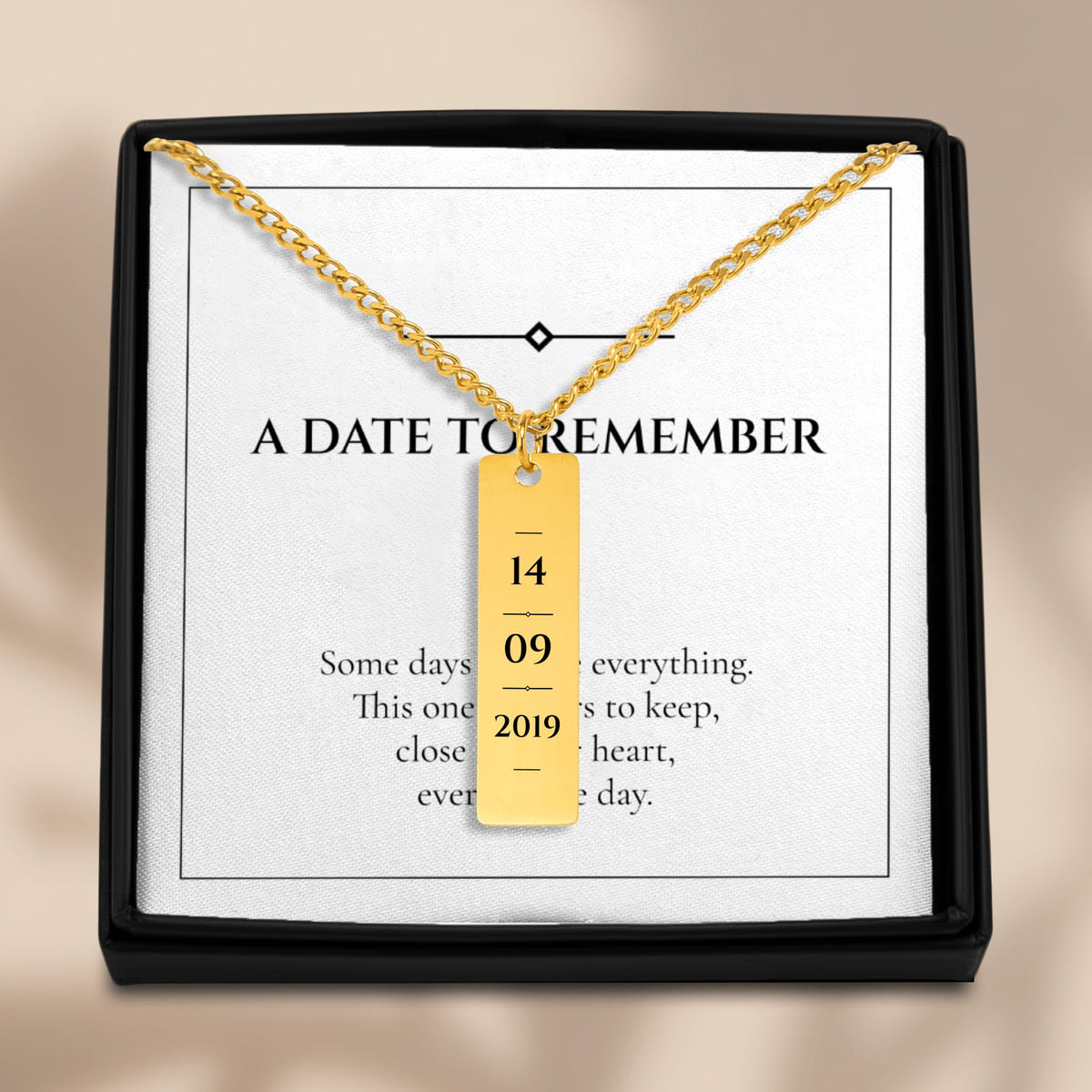 Date vertical bar necklace in an open gift box with its message card
