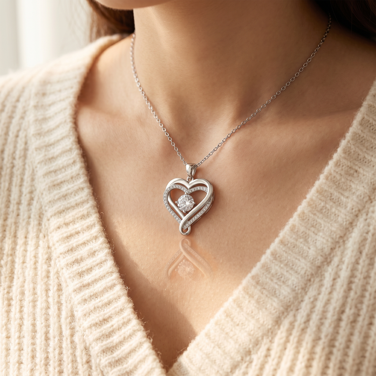 Woman in a cream sweater wearing the ribbon heart pendant | Love You Always Necklace