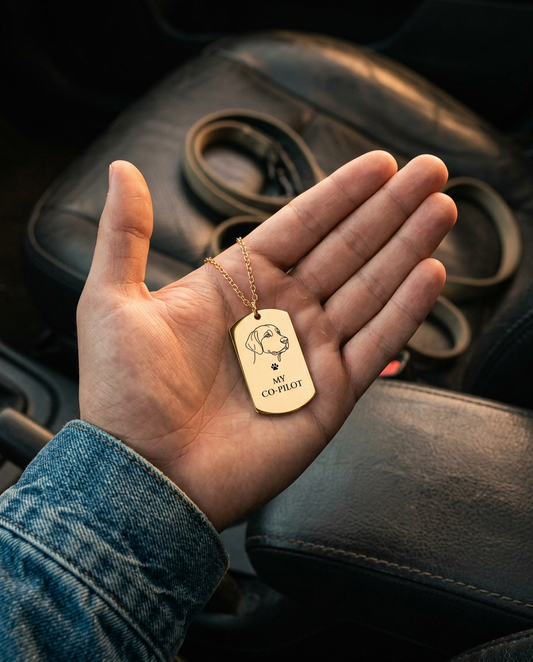 My Co-Pilot dog tag necklace resting in a man's open hand inside a car (styled lifestyle image)
