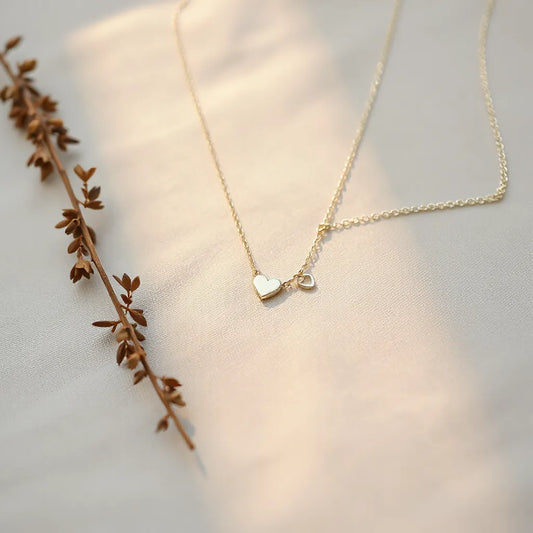 Delicate forever love necklace with heart pendant resting on neutral fabric under soft light