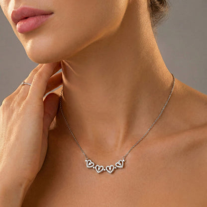 Woman touching her neck while wearing the row of hearts | Magnetic Hearts Necklace