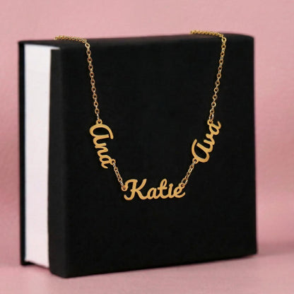 Gold finish three-name necklace draped over a black gift box | Multiple Name Necklace