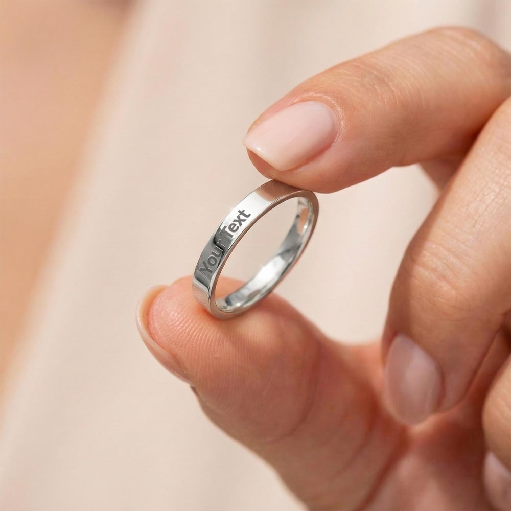 Stainless steel engraved ring held between her fingers | Engraved Women's Ring
