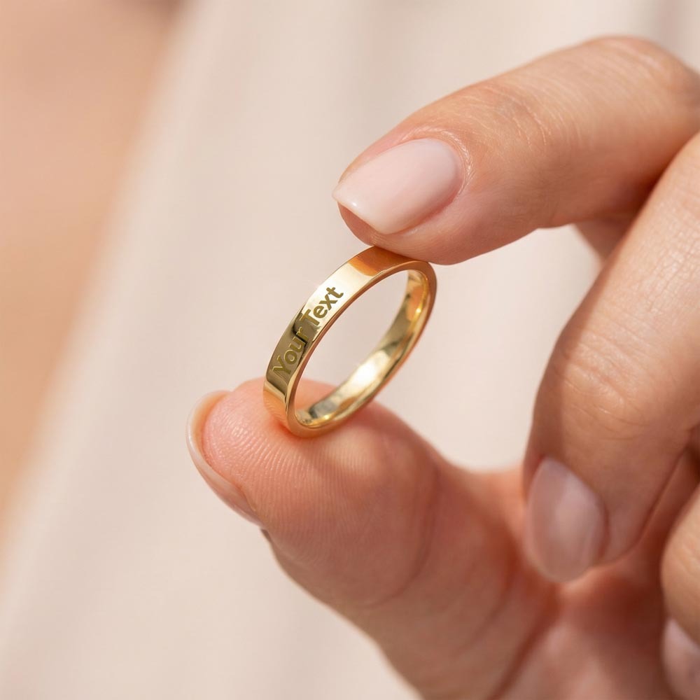 Gold finish engraved ring held between her fingers | Engraved Women's Ring