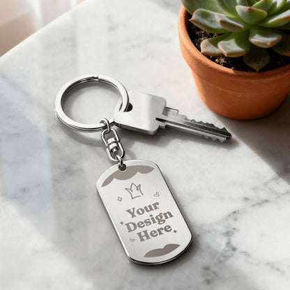 Steel dog tag keychain on a marble surface beside a plant | Engraved Dog Tag Keychain