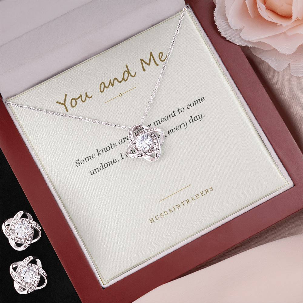 Love Knot set in the mahogany Luxury Box beside earrings on pink | Love Knot Necklace and Earring Set