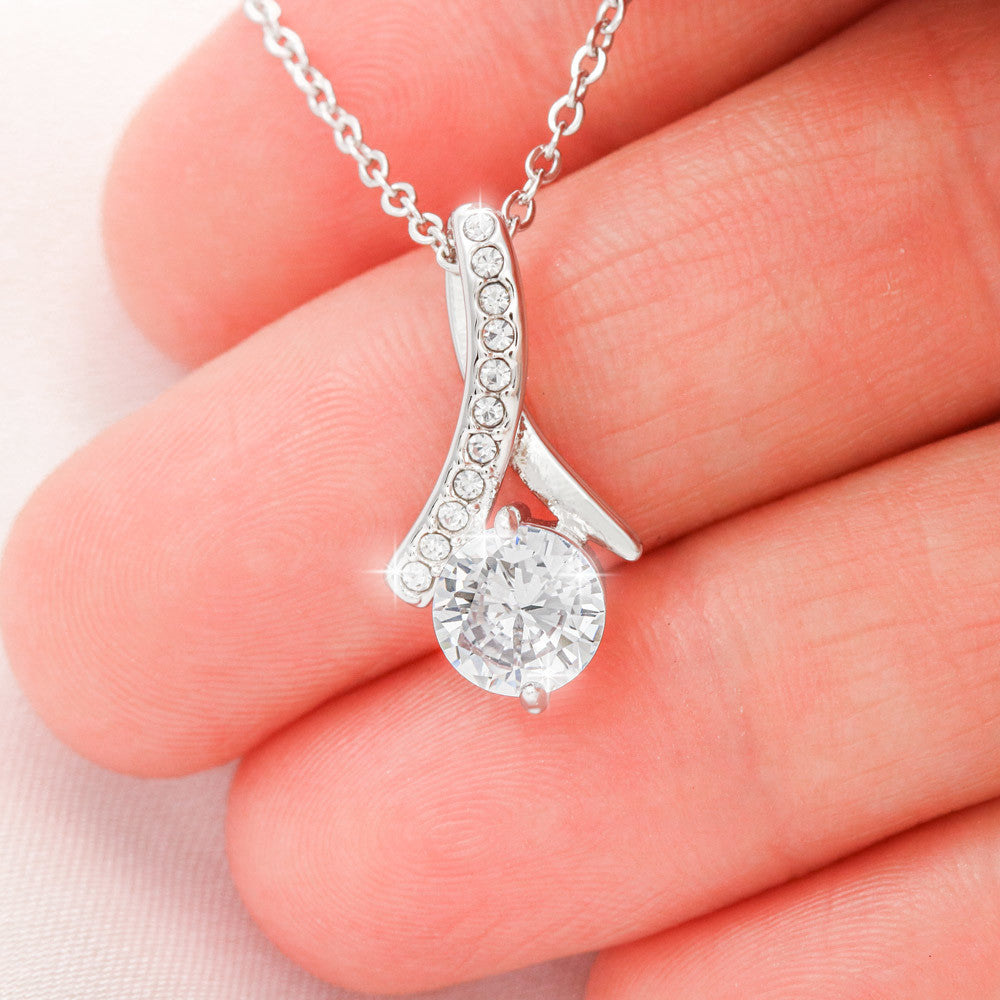 Close view of the crystal and ribbon setting on a fingertip | Proud Mom Necklace