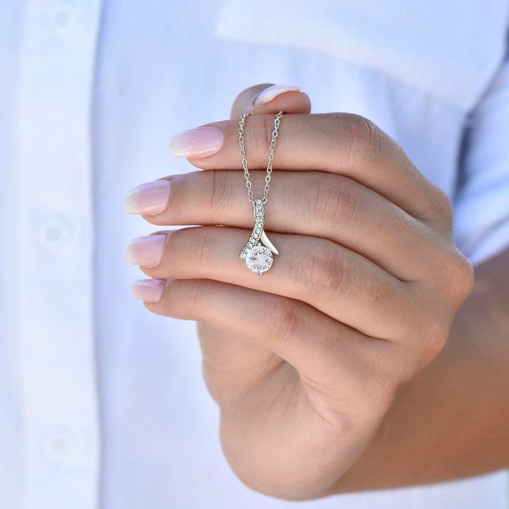 Hand in a blue sleeve holding the white gold finish pendant | Proud Mom Necklace