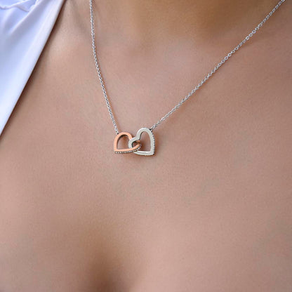 Steel and rose gold interlocking hearts worn with a white top, close view | Always Proud, Always Loved Necklace