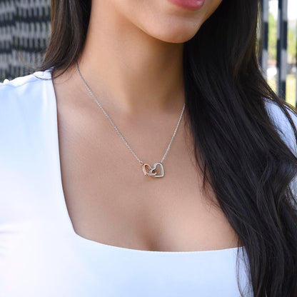 Woman in a white top wearing the steel and rose gold interlocking hearts | Always Proud, Always Loved Necklace