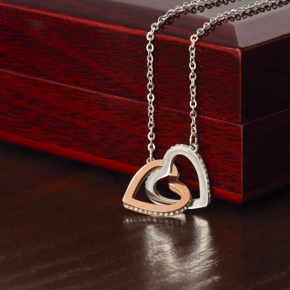 Steel and rose gold hearts draped over the mahogany Luxury Box | Always Proud, Always Loved Necklace