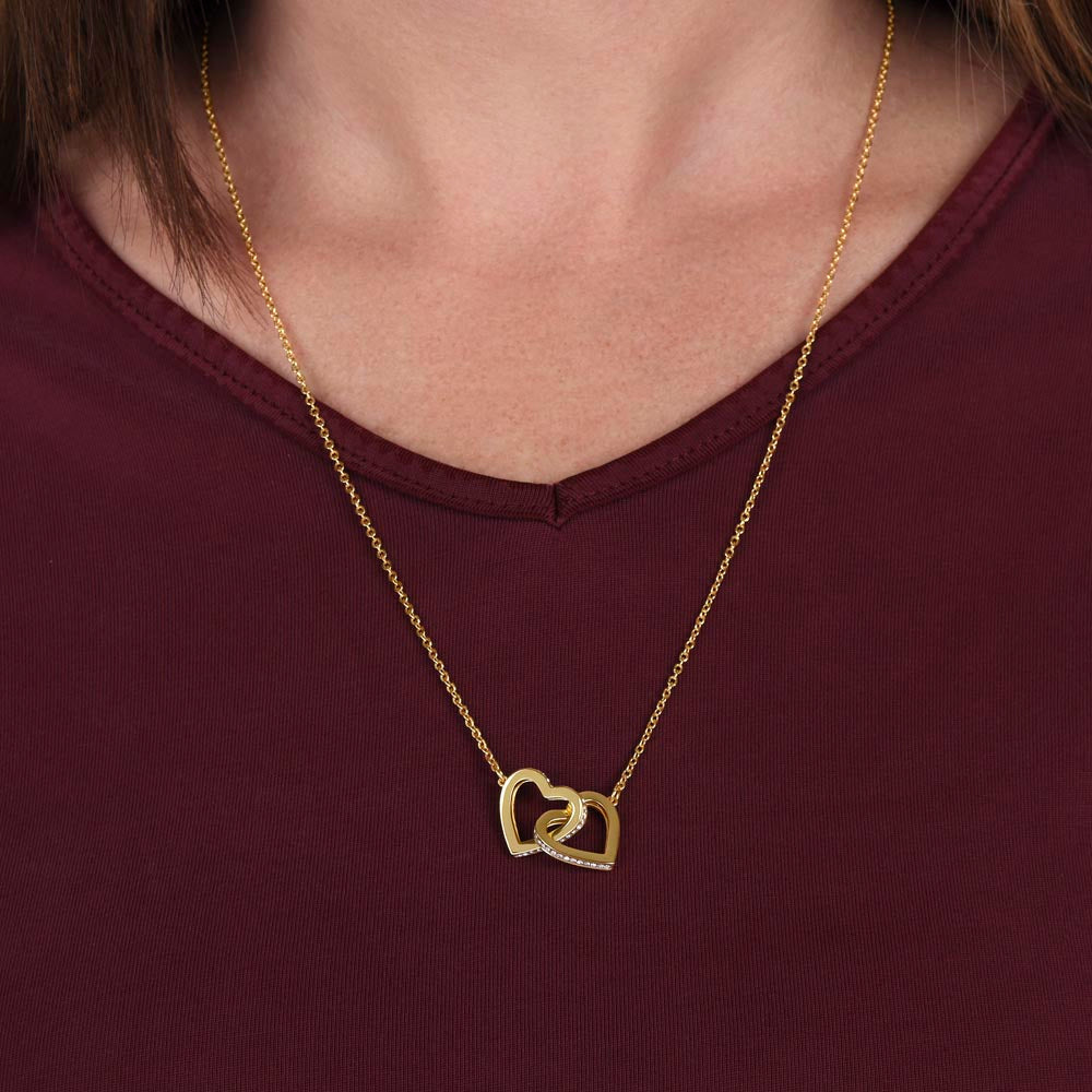 Yellow gold finish hearts worn with a burgundy top | Interlocking Hearts Necklace
