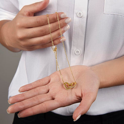 Open hand holding the yellow gold finish hearts pendant | Interlocking Hearts Necklace