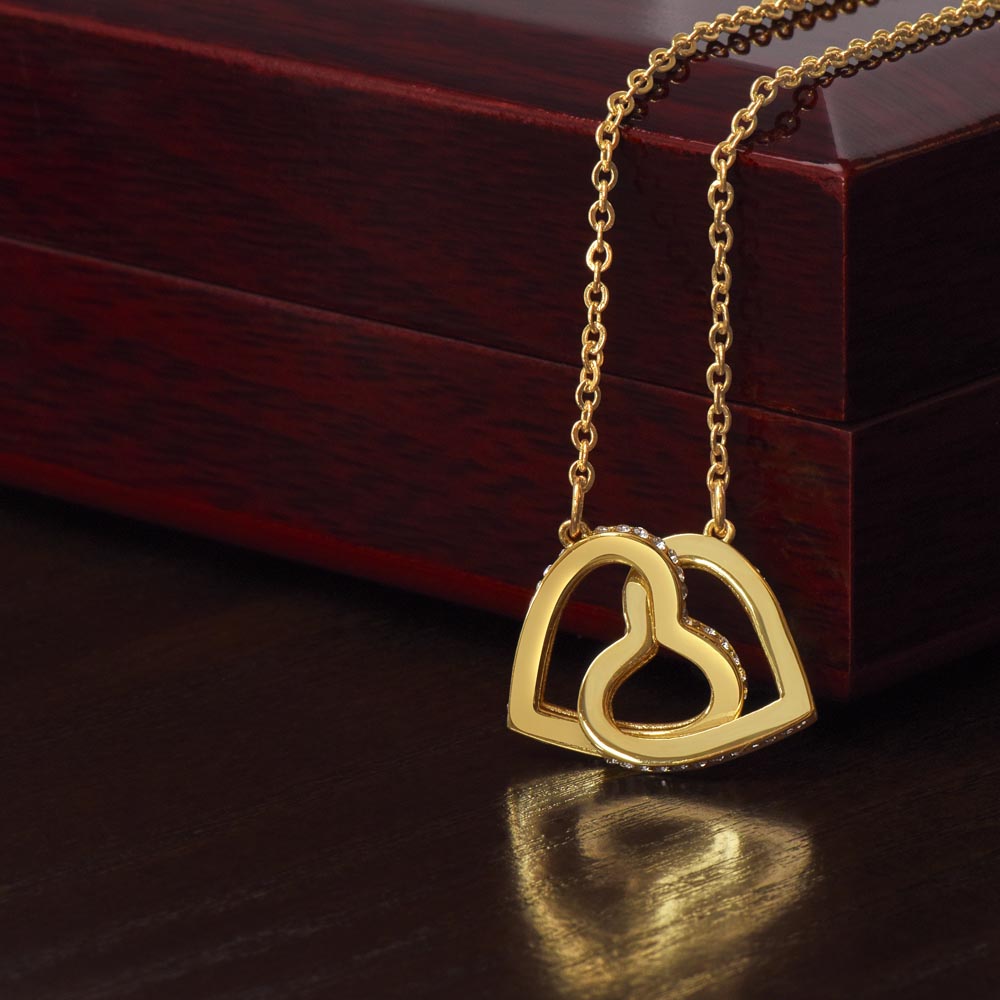 Yellow gold finish hearts draped over the mahogany Luxury Box | Interlocking Hearts Necklace