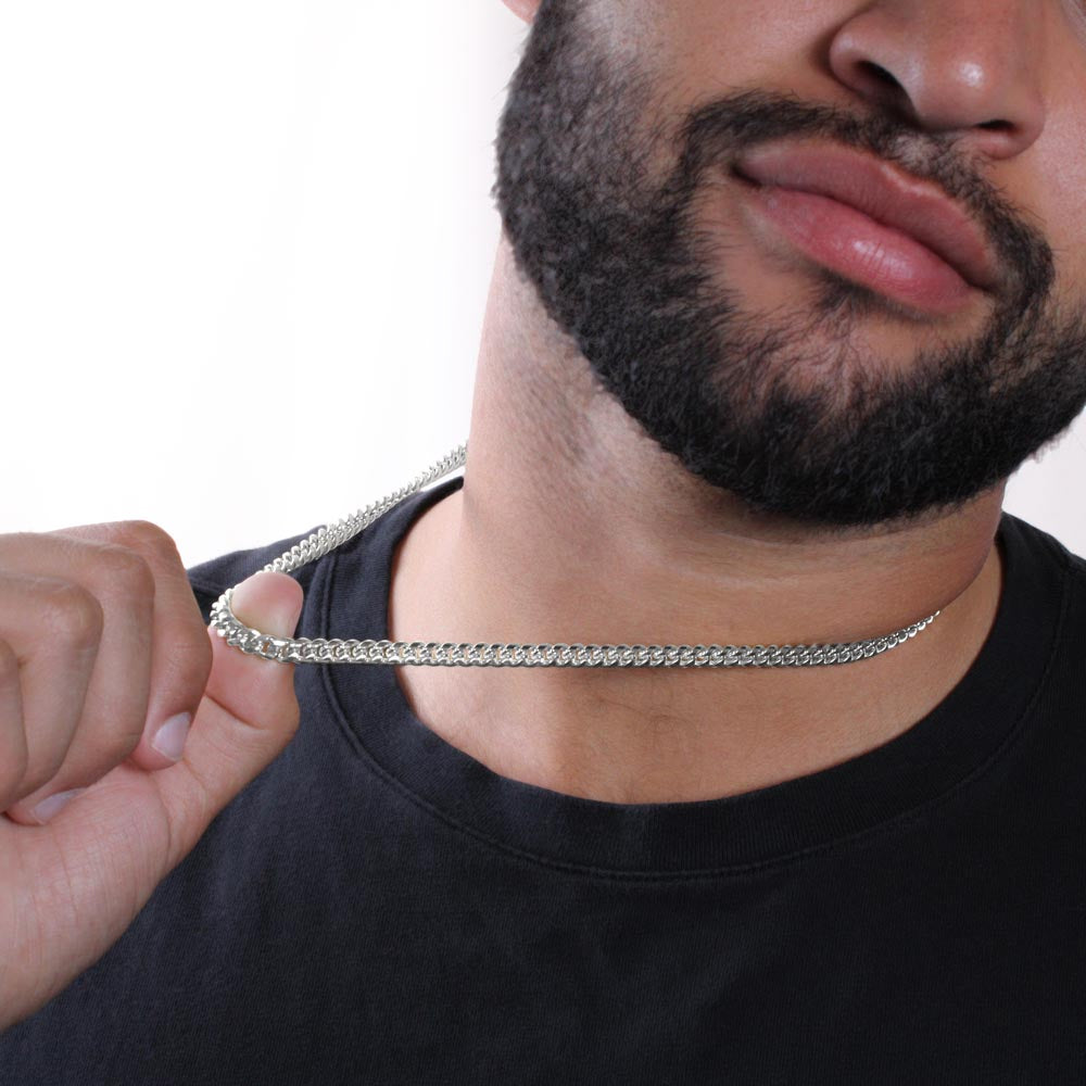 Man holding the steel Cuban chain between his fingers | Cuban Link Chain