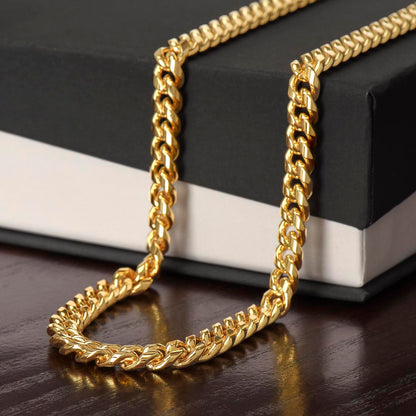 18k yellow gold finish Cuban link chain draped over a black gift box | Cuban Link Chain