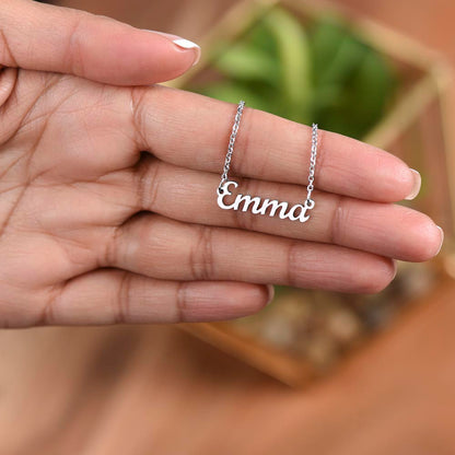 Silver name necklace held over a plant, close-up | Chosen Name Necklace