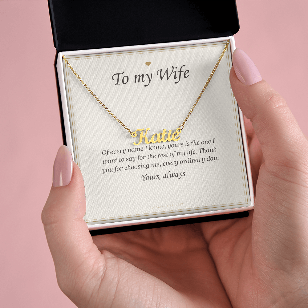 Hands holding the gold finish pendant and card over a pink background | Wife Name Necklace with Message Card