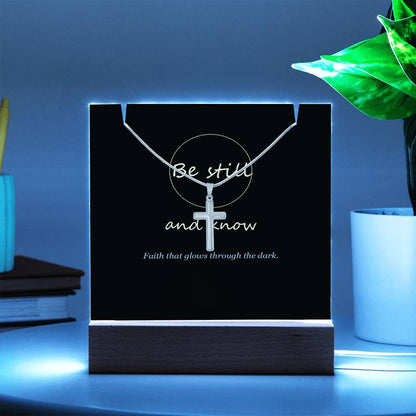 Keepsake light glowing blue beside a plant | Be Still Keepsake Light & Cross Necklace