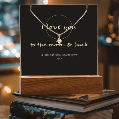 Moon and back keepsake light on a stack of books, angled | To the Moon & Back Keepsake Light & Necklace