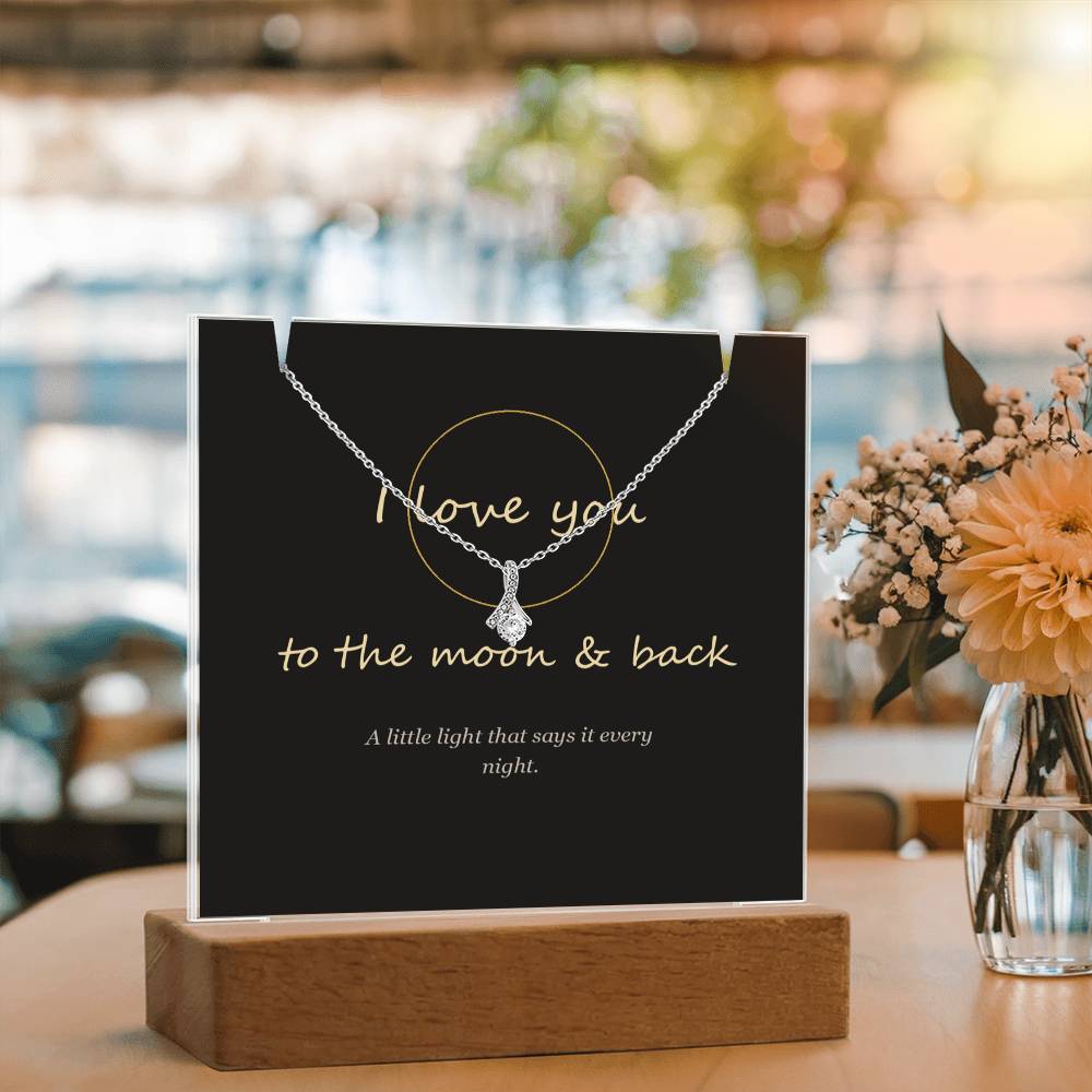 Moon and back keepsake light beside flowers, angled | To the Moon & Back Keepsake Light & Necklace