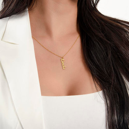 Gold finish vertical name necklace worn with a white top | Stacked Vertical Names Necklace