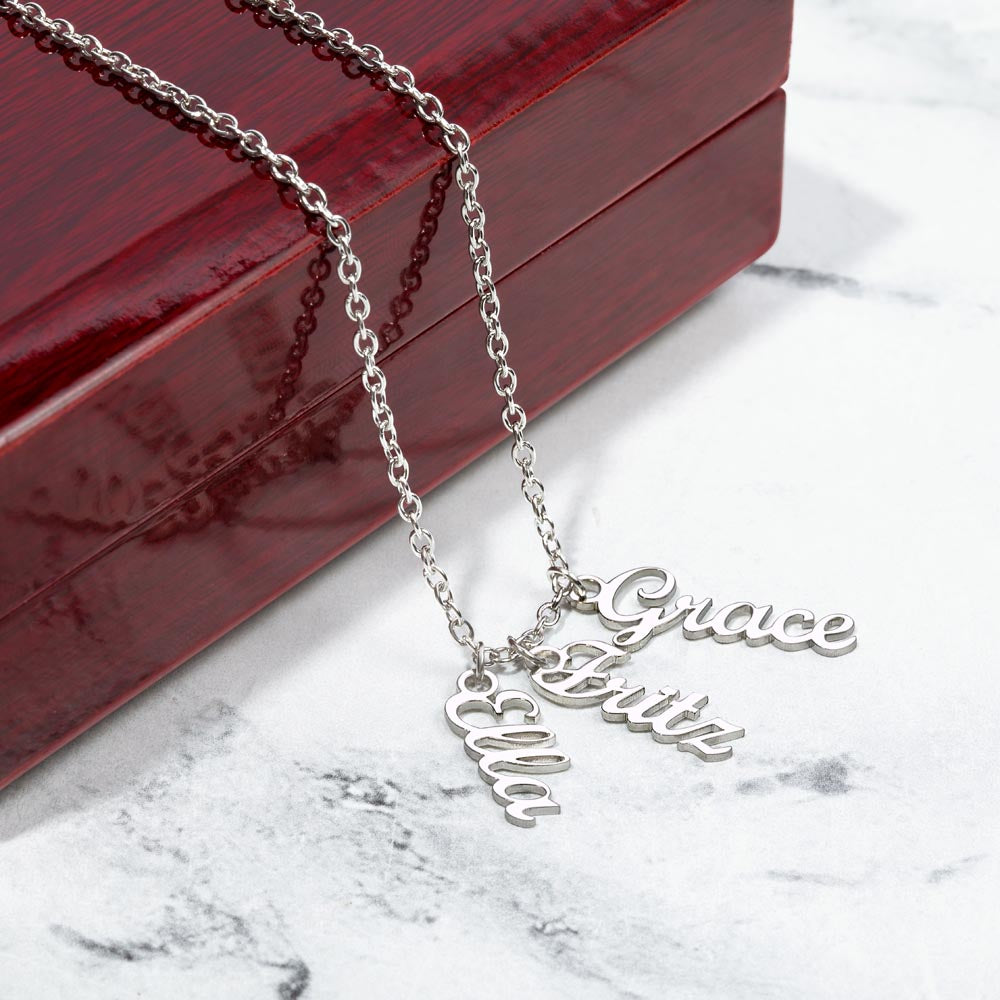 Three silver vertical names on marble beside a gift box | Stacked Vertical Names Necklace