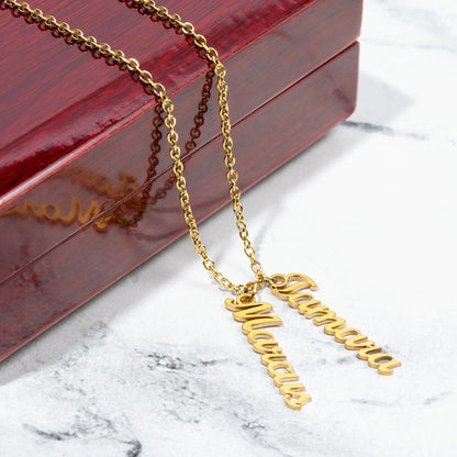 Two gold finish vertical names on marble beside a gift box | Stacked Vertical Names Necklace