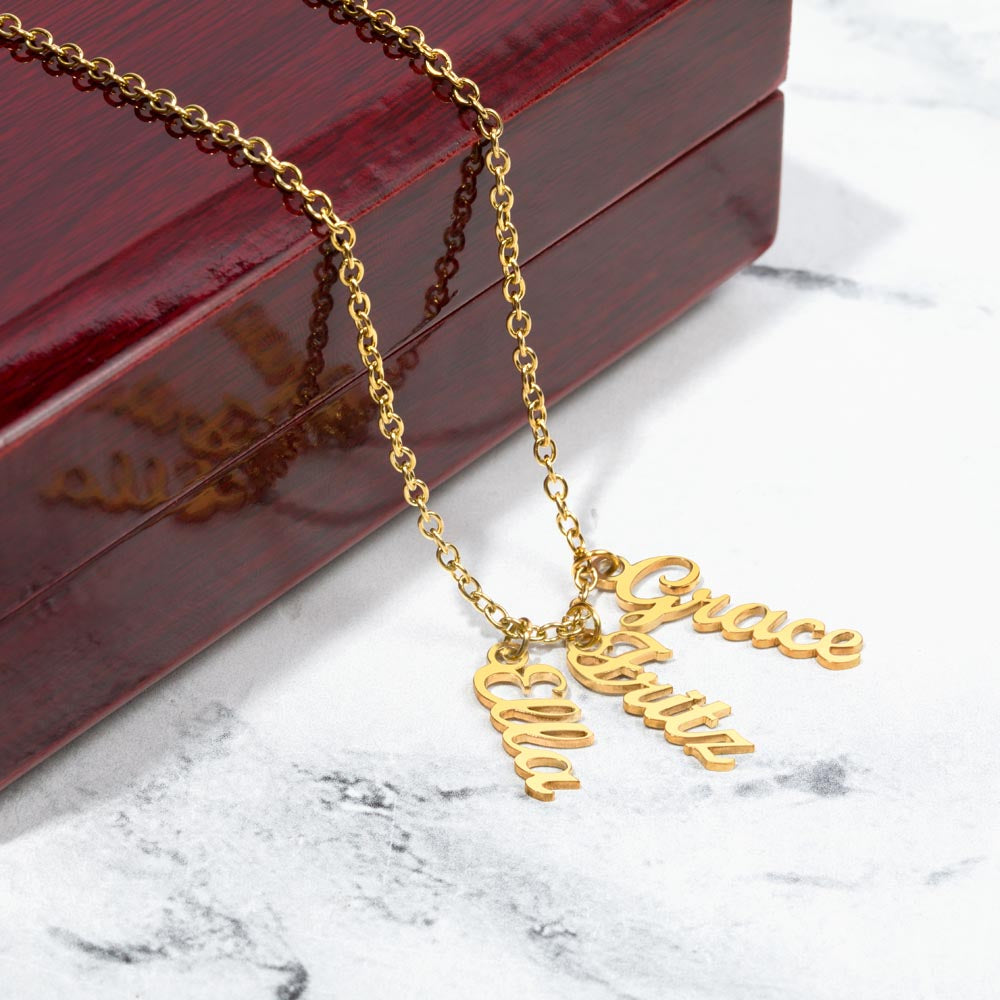 Three gold finish vertical names on marble beside a gift box | Stacked Vertical Names Necklace