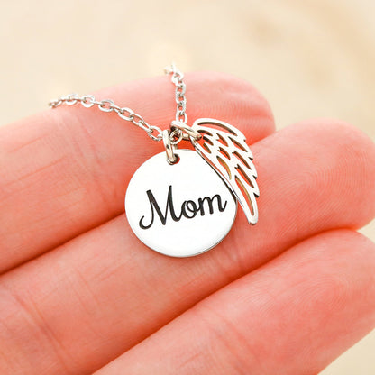 Silver Mom disc and angel wing charm held between the fingers | Memorial Necklace for Mom