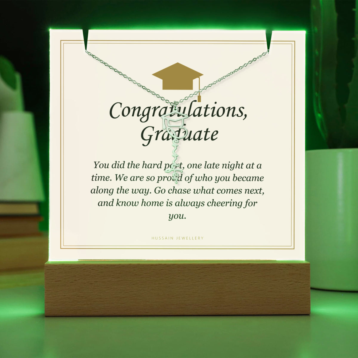 Graduate keepsake glowing green on its LED base, with the name necklace | Graduation Cap Name Necklace and Keepsake Light