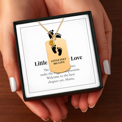 Hands holding the Little Feet, Big Love necklace gift box