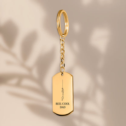 Reel Cool Dad fishing tag keychain in soft window light