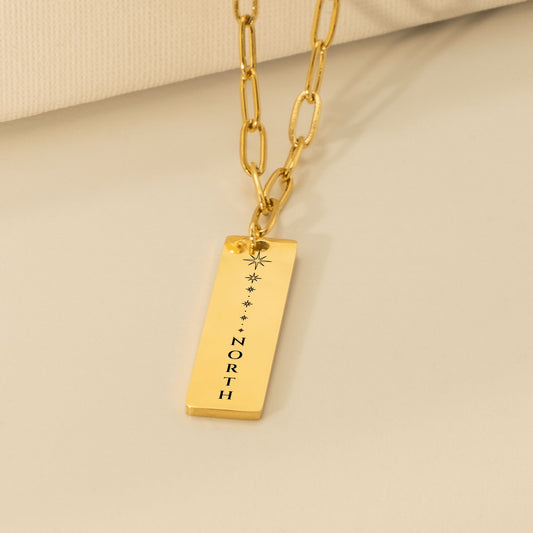 Vertical bar pendant engraved with north star sparkles and stacked NORTH lettering