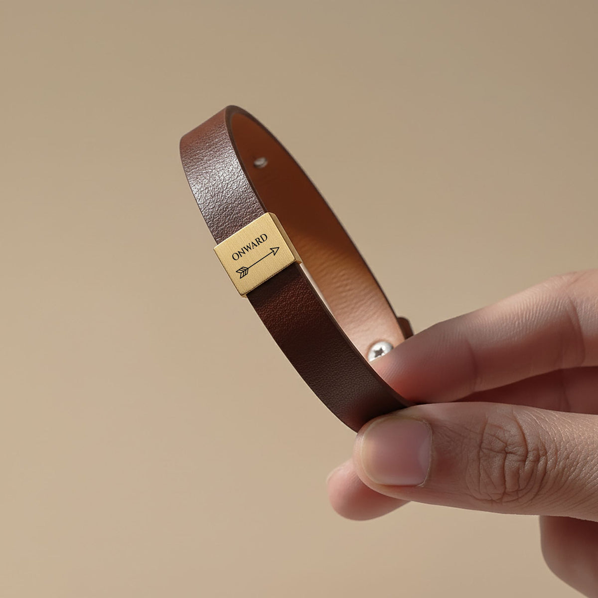 Brown vegan leather bracelet with a gold plate engraved ONWARD and an arrow