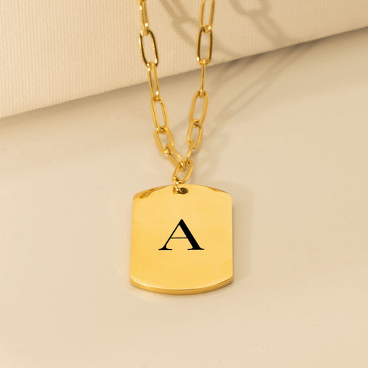 Gold tag pendant engraved with a large serif initial A on a paperclip chain