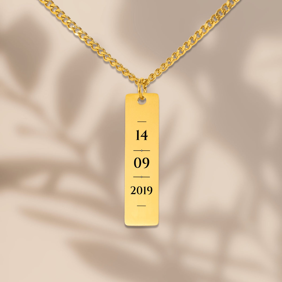 Engraved date vertical bar necklace in soft window light