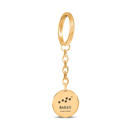Gold coin keychain engraved with paw prints, the sample name BAILEY and MY BEST FRIEND