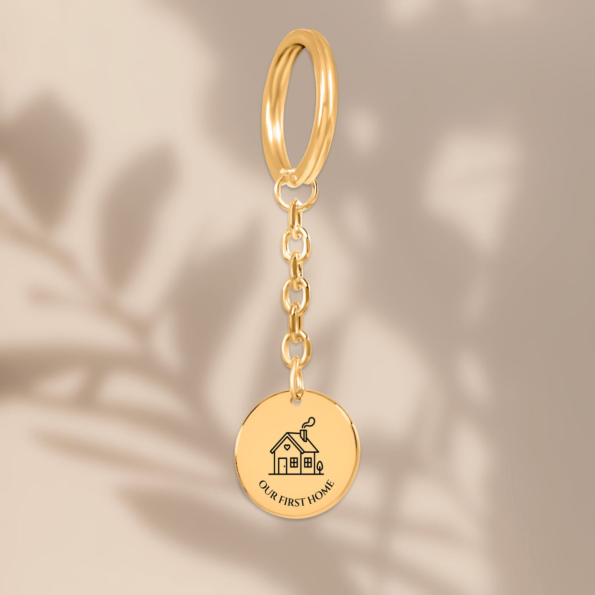 Our First Home coin keychain with soft leaf shadows