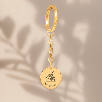 Our First Home coin keychain with soft leaf shadows