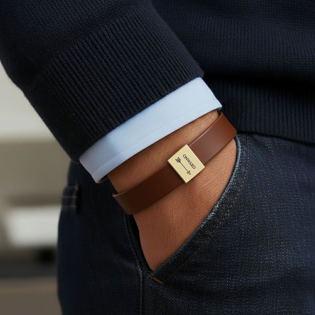 Onward arrow leather bracelet worn with a navy suit sleeve