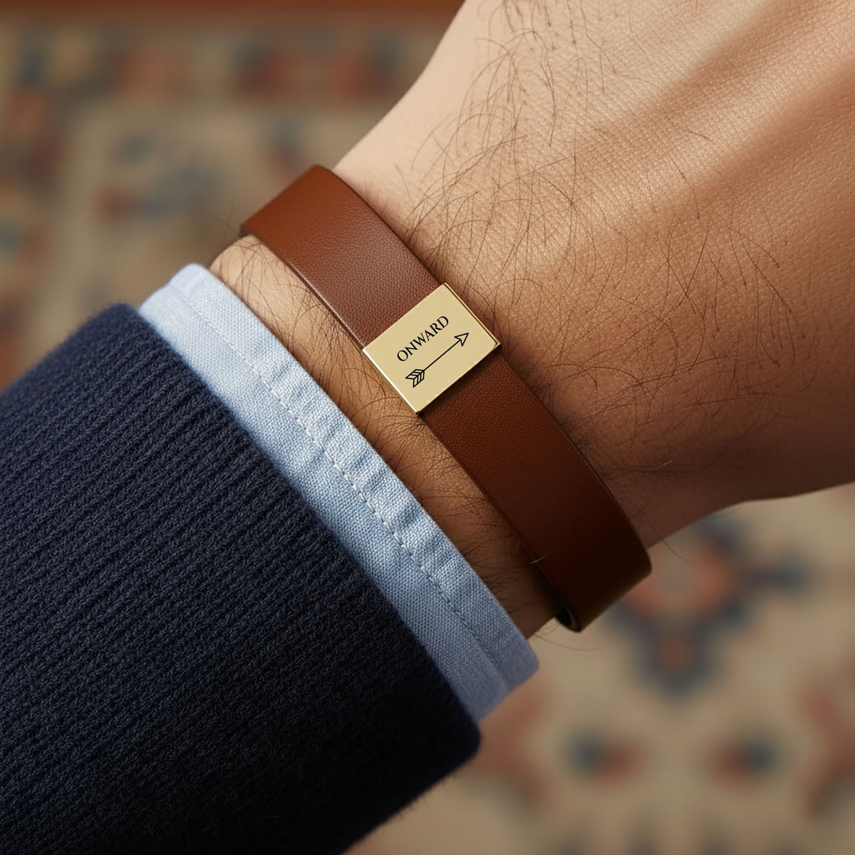 Man wearing the Onward arrow engraved brown vegan leather bracelet with a gold plate