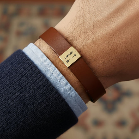 Man wearing the Onward arrow engraved brown vegan leather bracelet with a gold plate