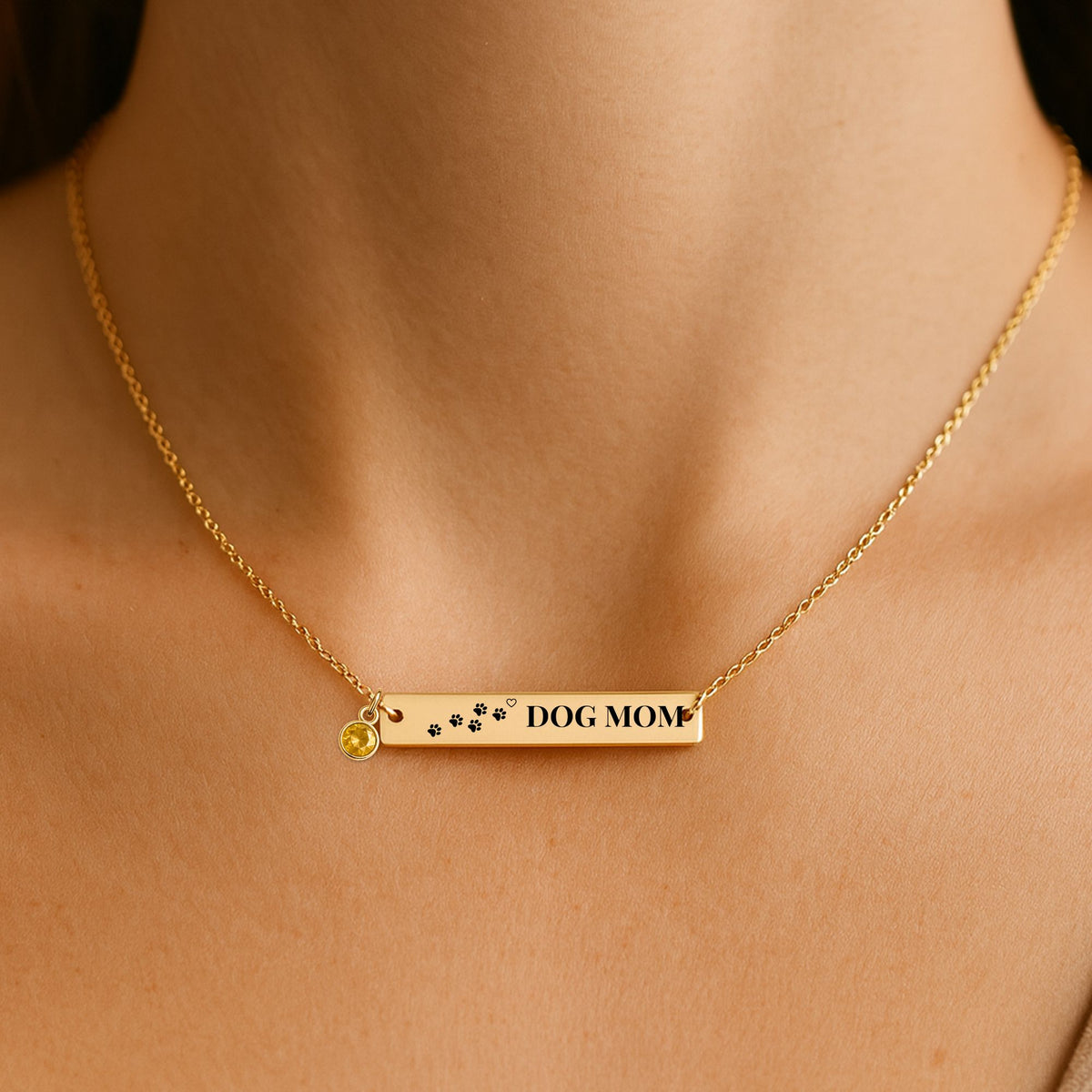 Dog Mom paw print bar necklace worn at the collarbone