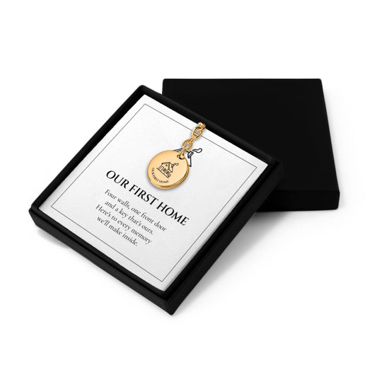Our First Home keychain in an open black gift box