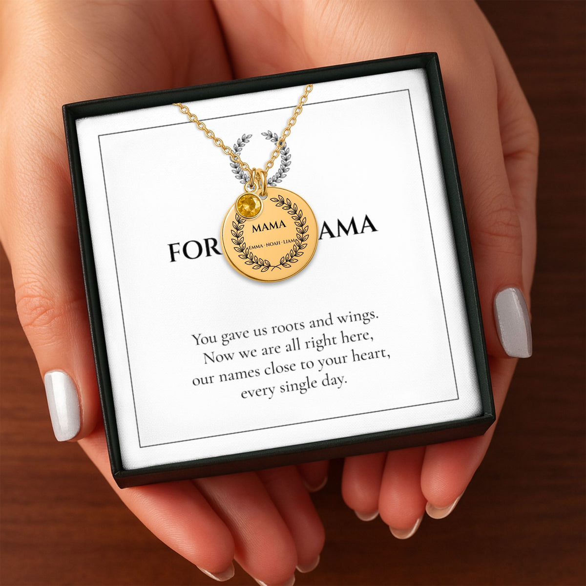 Hands holding the FOR OUR MAMA necklace gift box