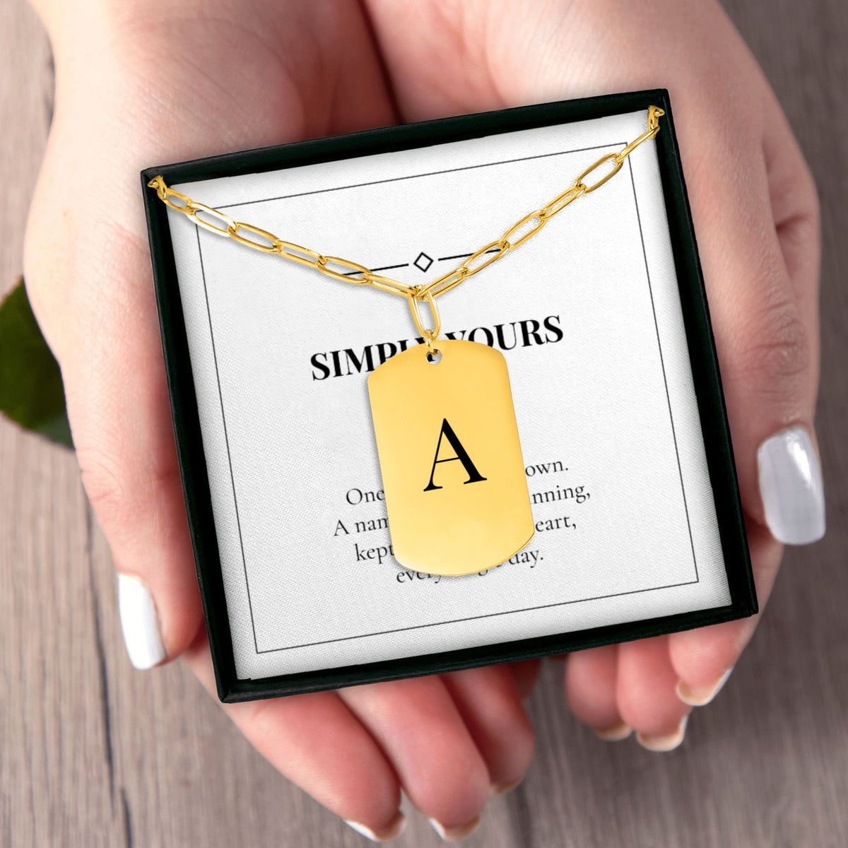 Hands holding the SIMPLY YOURS initial necklace gift box