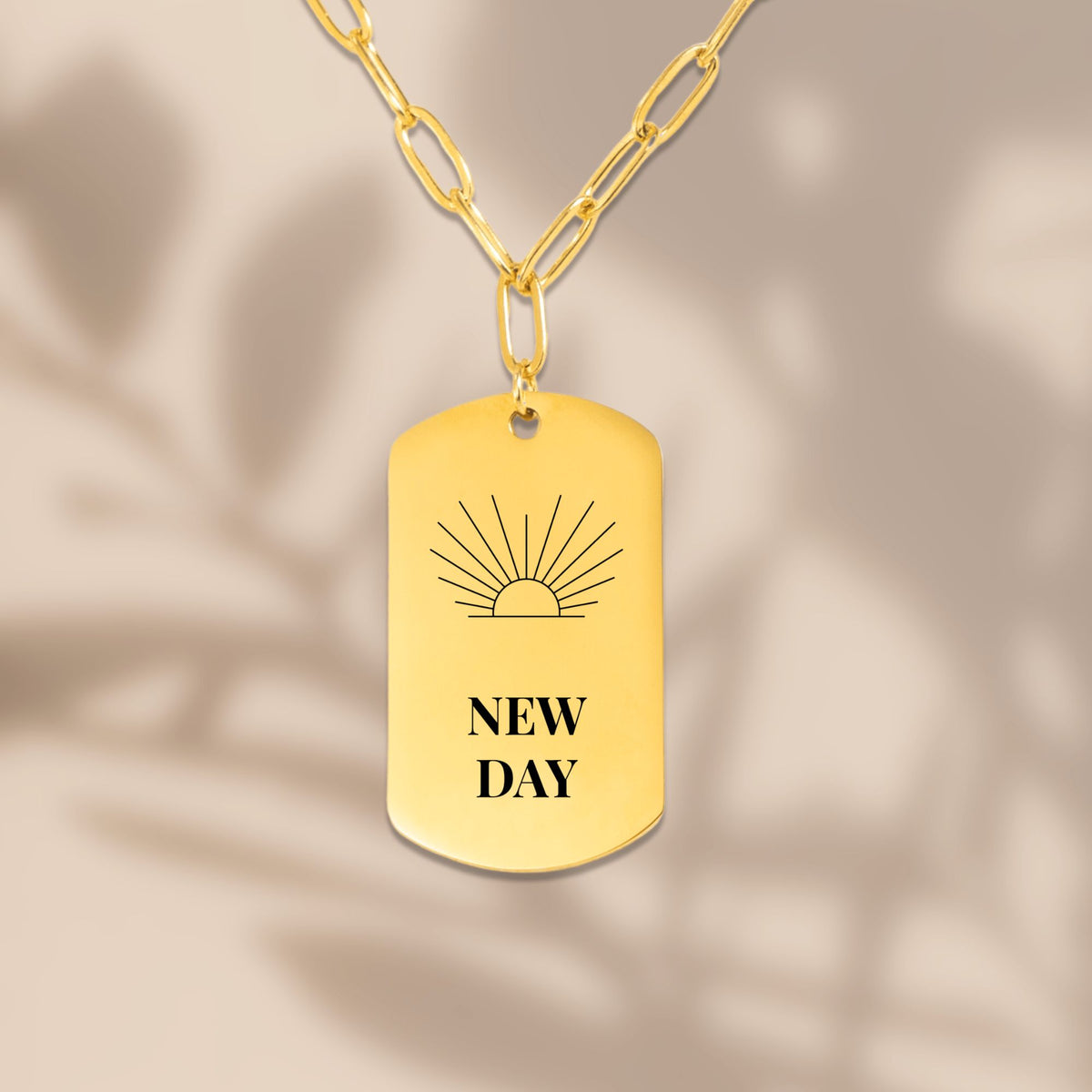 Sunrise engraved tag pendant with soft leaf shadows