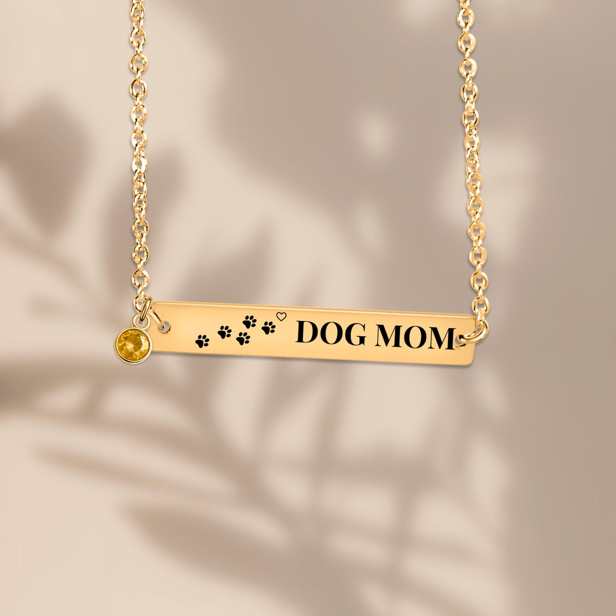 Paw print DOG MOM bar pendant with soft leaf shadows