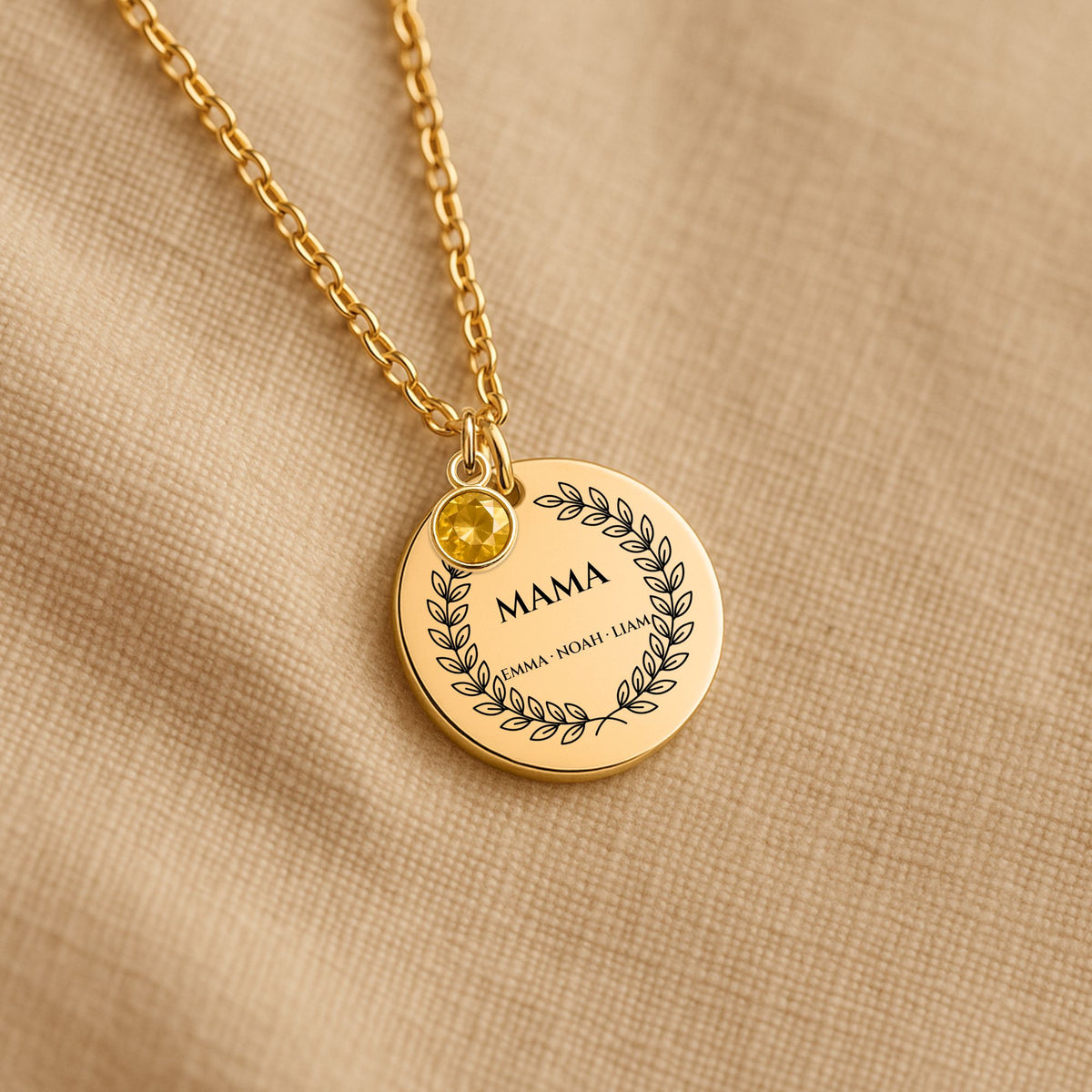 Gold Mama coin necklace with a birthstone colour charm on linen
